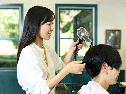 美容師に髪をカットしてもらう女性